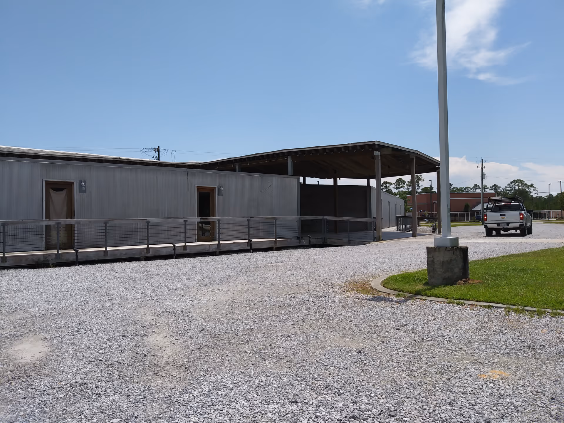 Exterior view of a Right at Home facility with a gravel lot and parked truck.