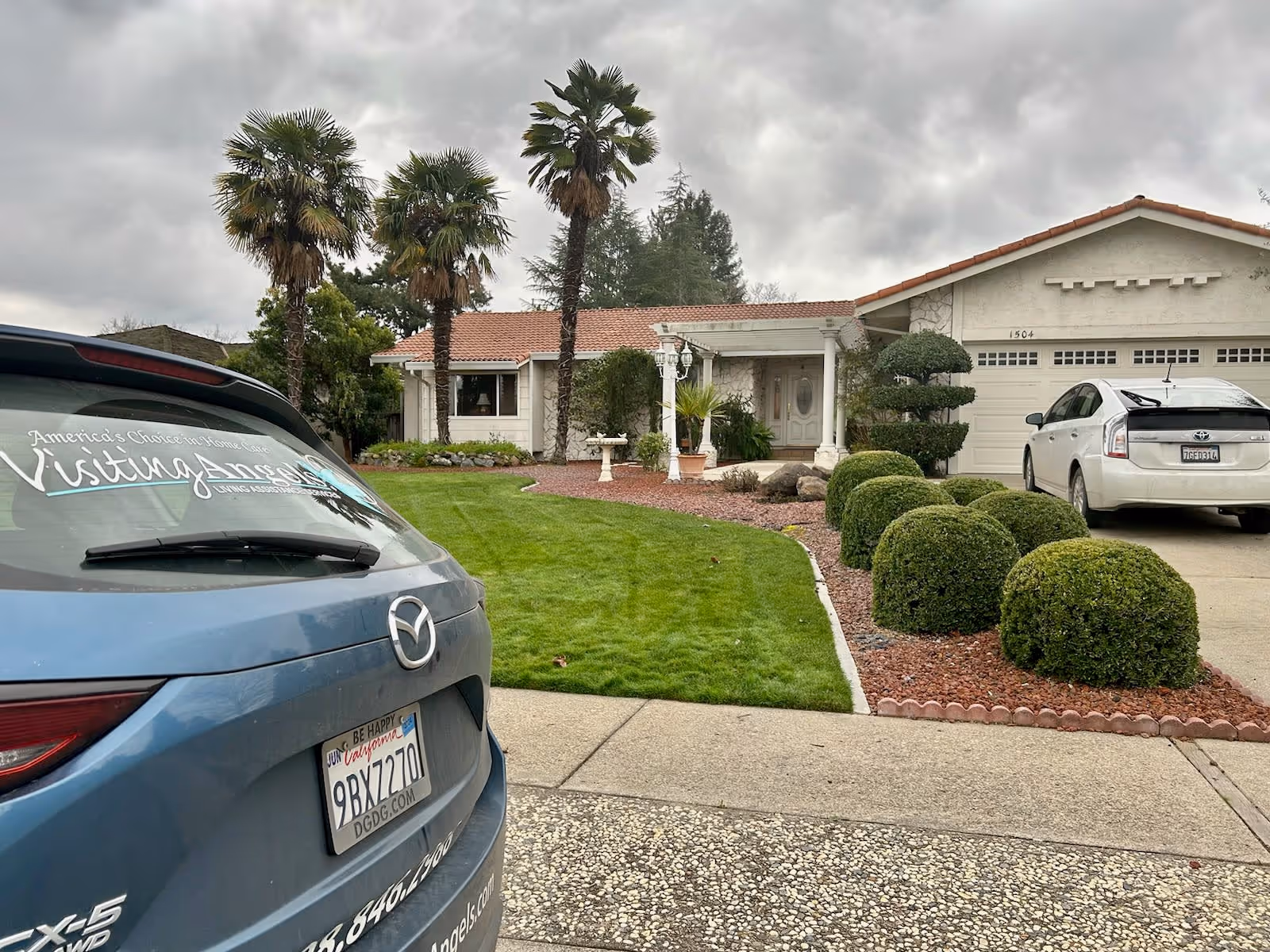 Front of Visiting Angels Senior Home Care facility with parked cars.