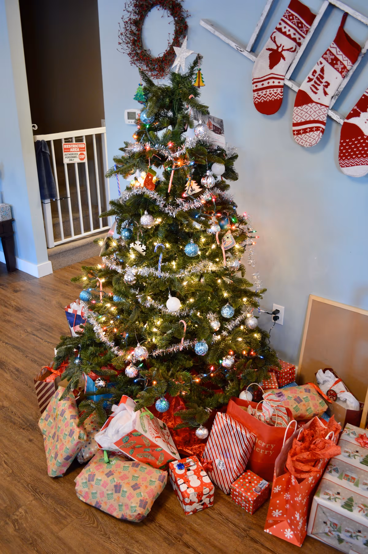 Indoor living area with a decorated Christmas tree and wrapped gifts.
