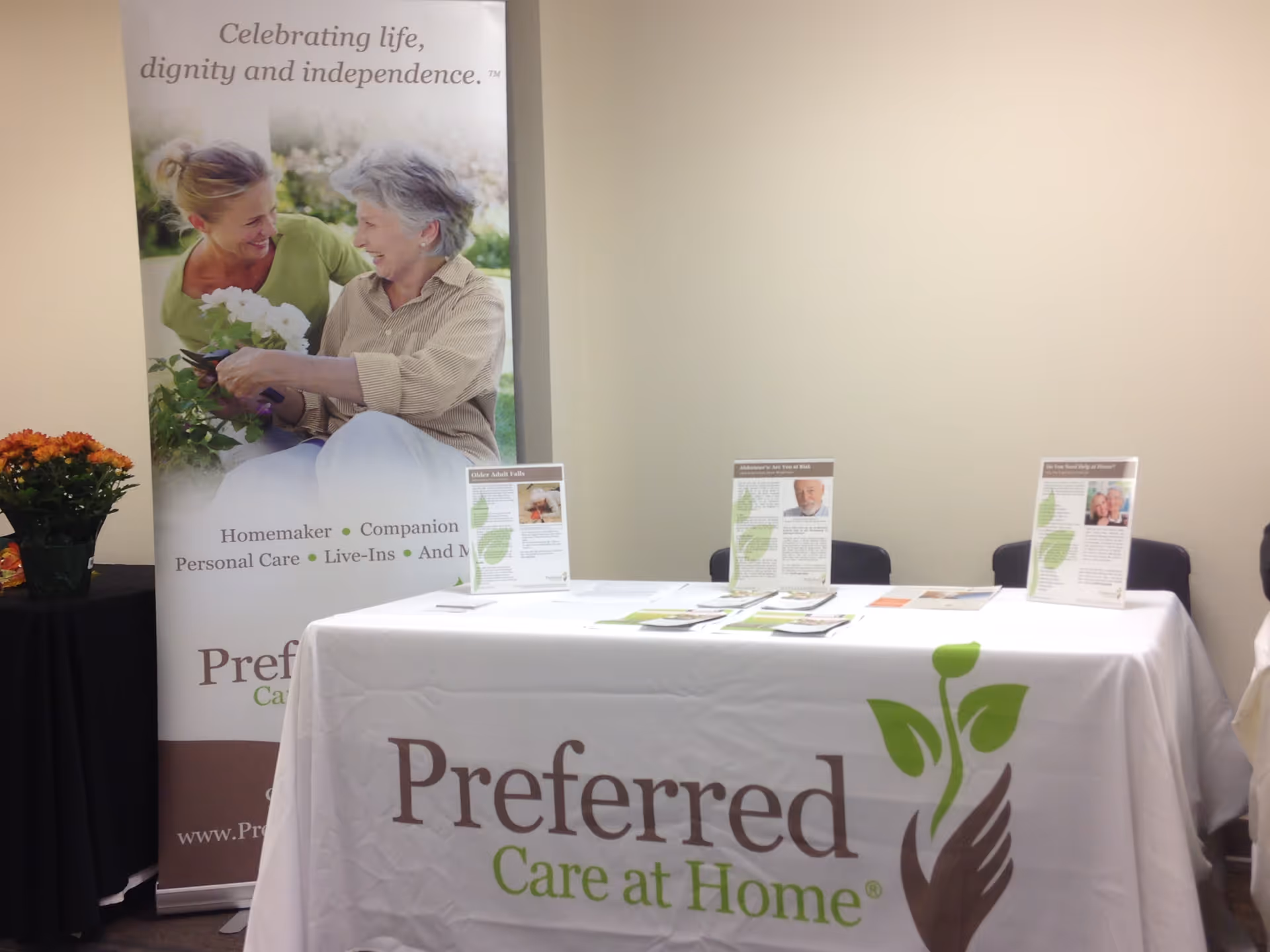 Indoor expo booth for Preferred Care at Home with banner and branded table.
