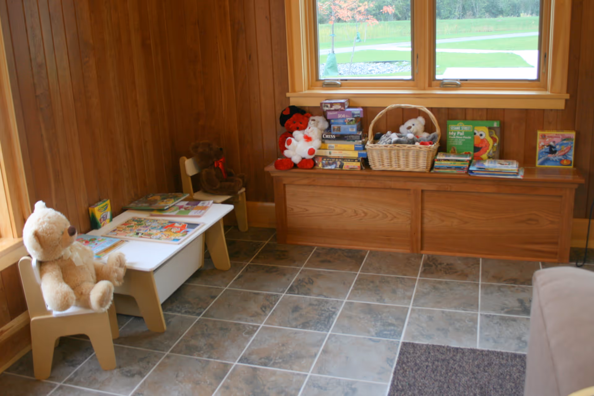Cozy interior play corner with stuffed animals, books, and a window to the outdoors.