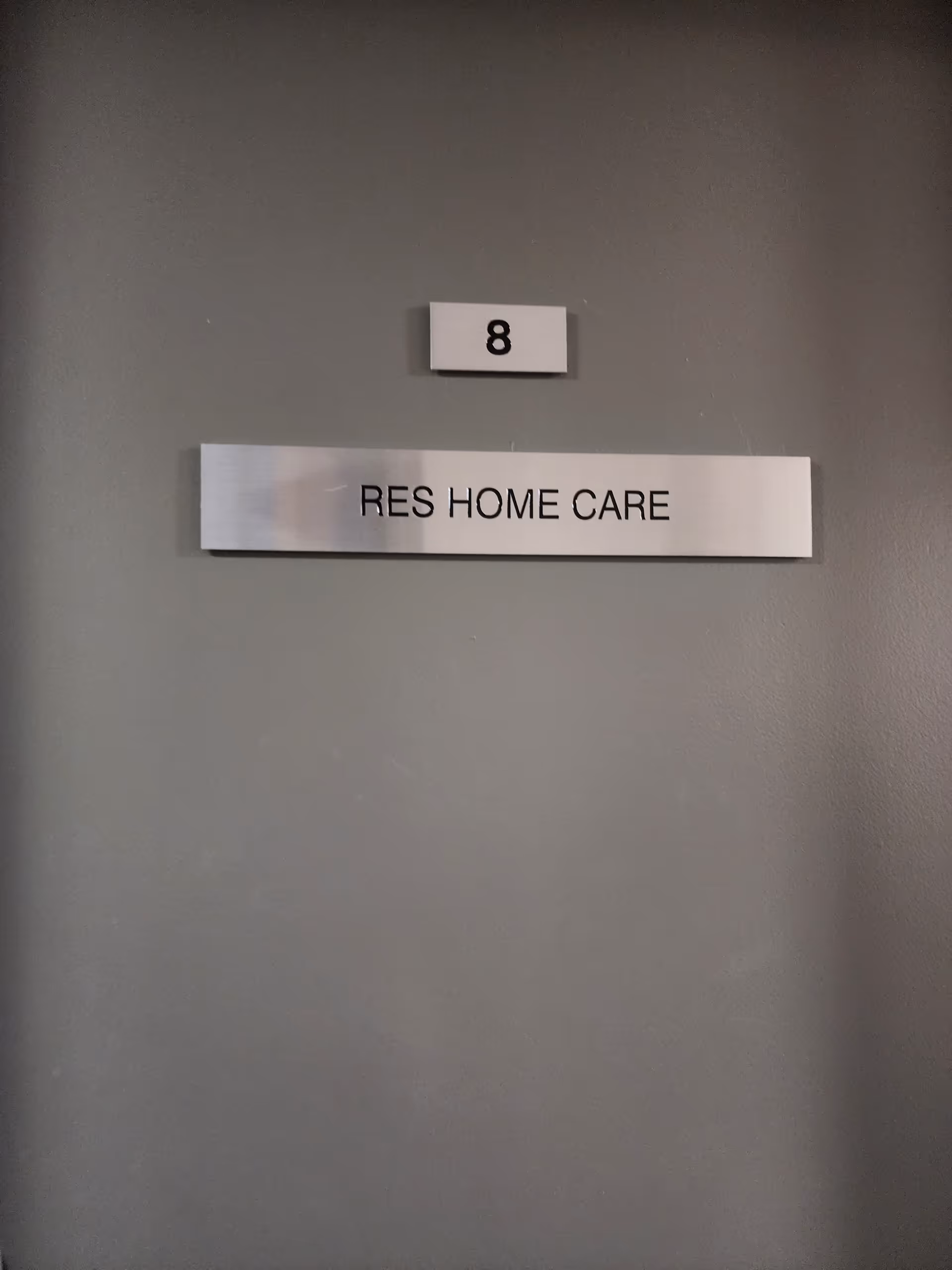 Hallway wall with number plaque '8' and metal sign 'RES HOME CARE'.
