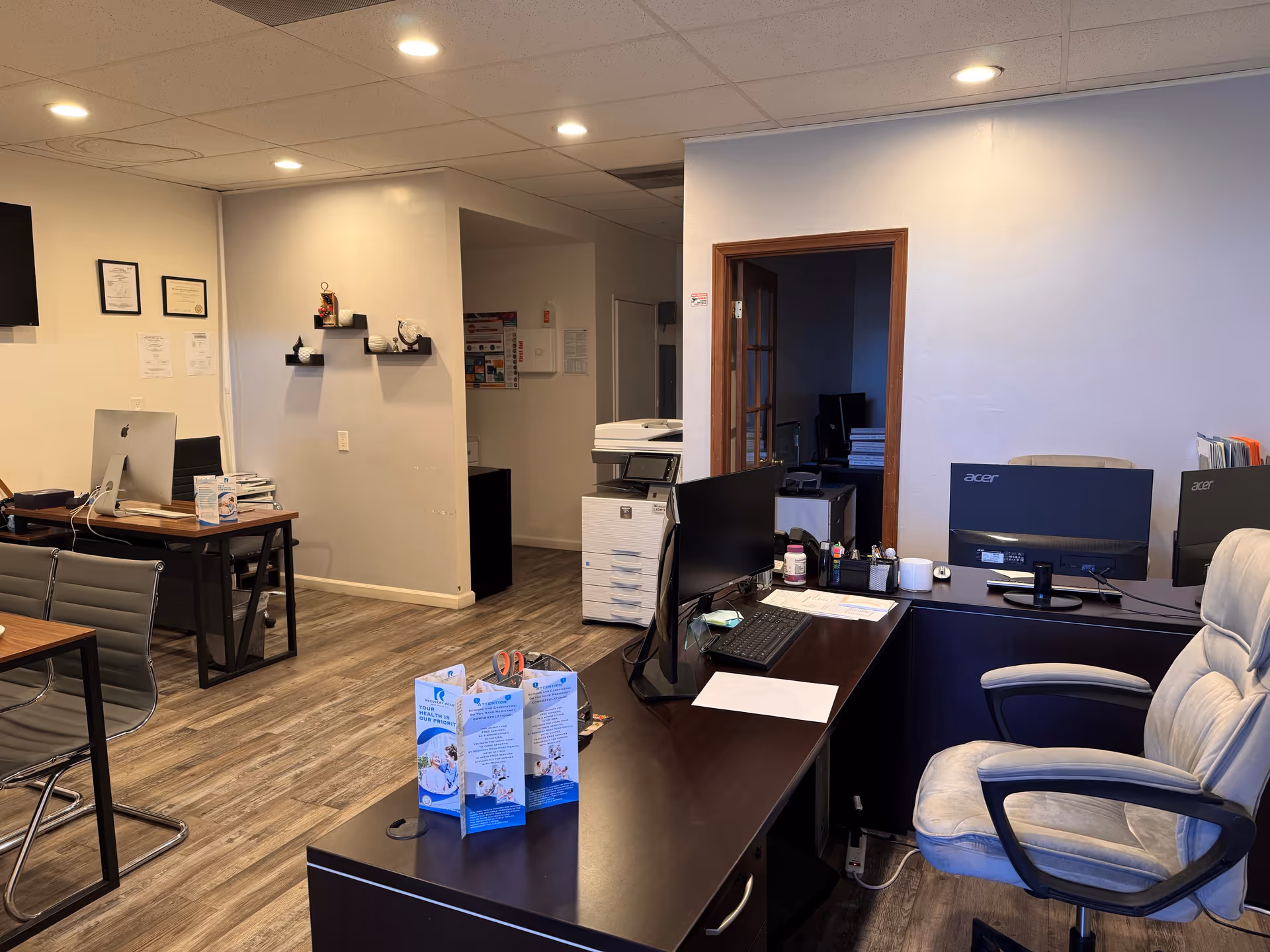 Office reception area with desks, computers, and seating in a professional facility.