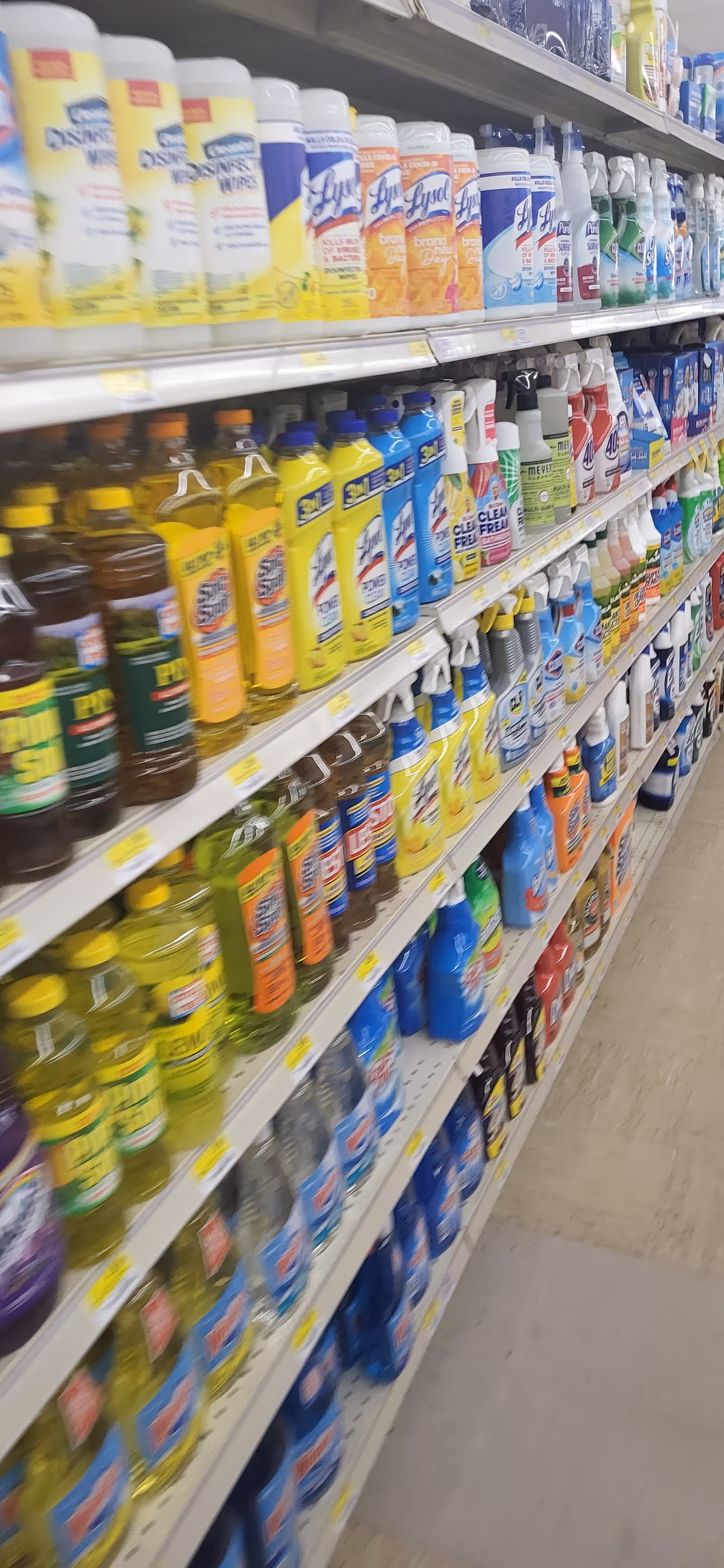 Aisle of cleaning and household products on shelves inside a store.