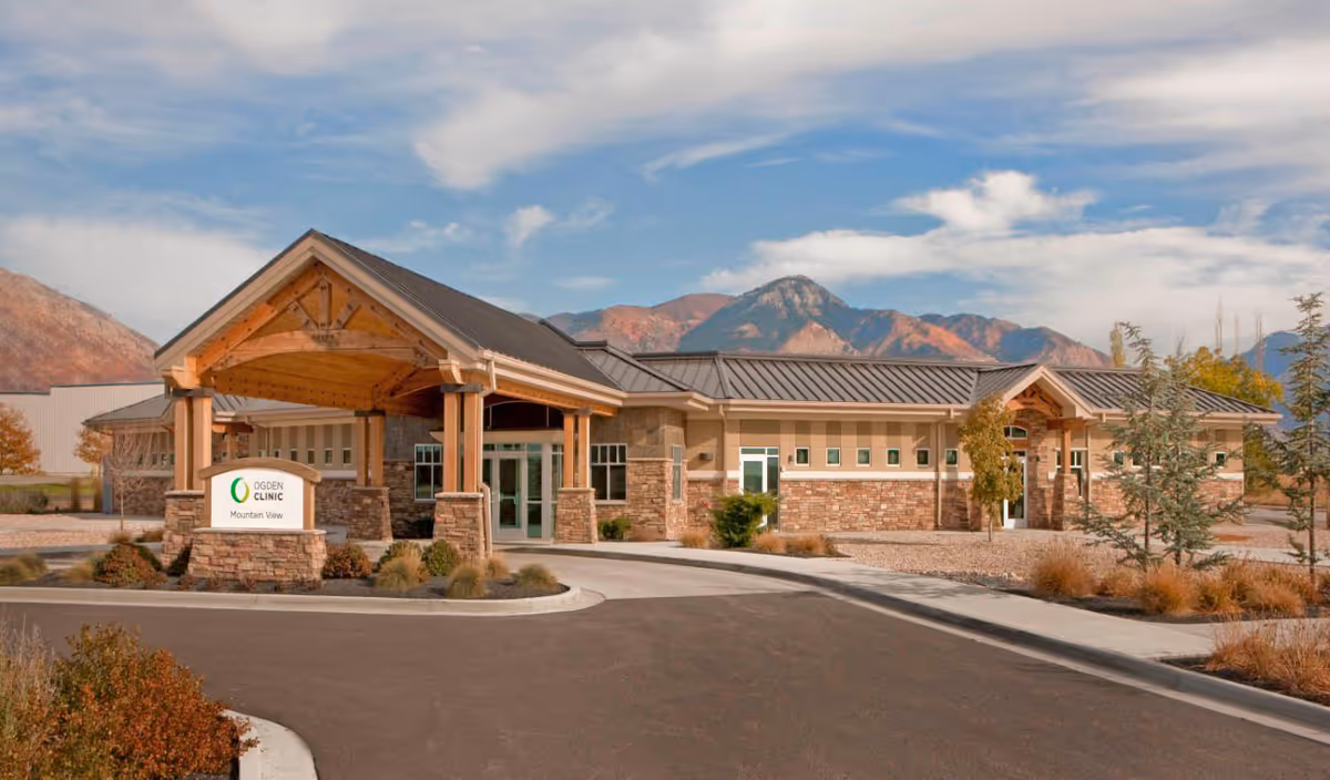 Exterior view of Ogden Clinic Mountain View facility with entrance canopy and mountains.