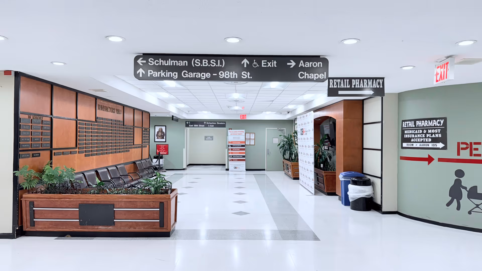 Hospital corridor at One Brooklyn Health-Brookdale University Hospital Medical Center with seating and signs.