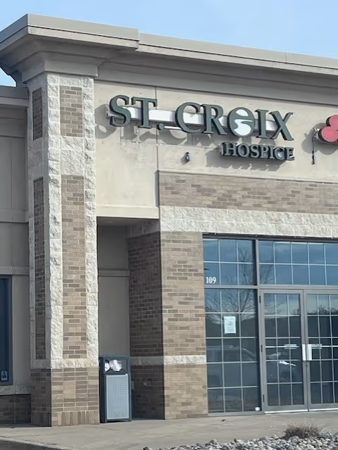 Exterior view of St. Croix Hospice building with brick facade and glass entrance.