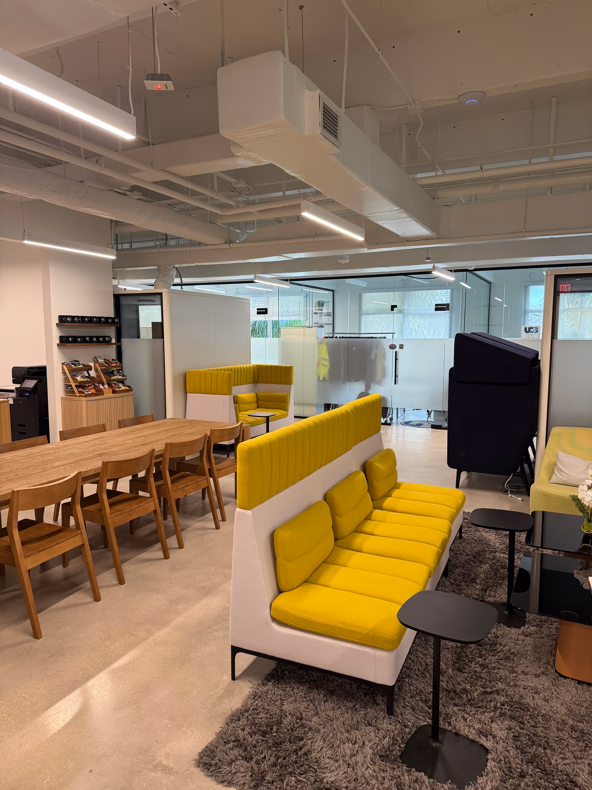 Modern interior dining area with yellow cushioned seating and wooden tables.