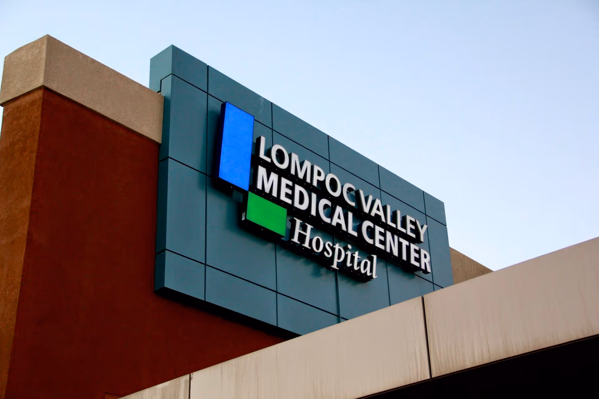 Exterior view of Lompoc Valley Medical Center hospital sign on facade.