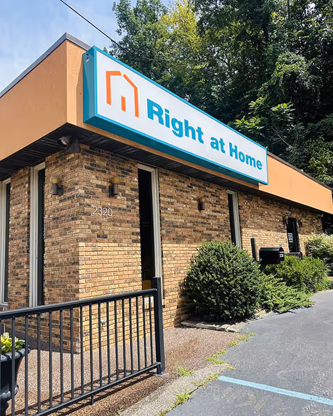 Exterior view of a Right at Home senior living facility with brick facade and sign.