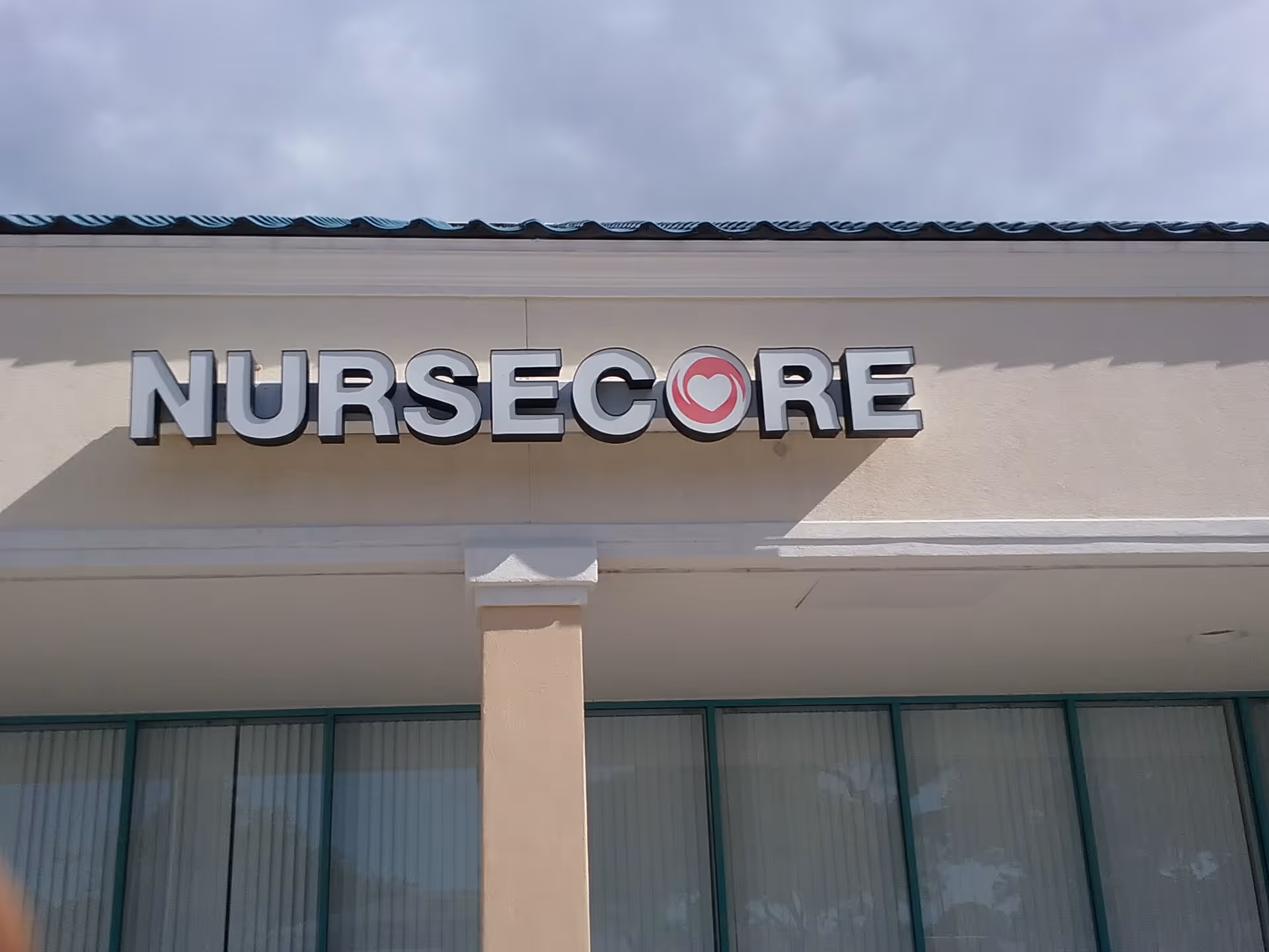 Exterior view of NurseCore building with large sign on front.
