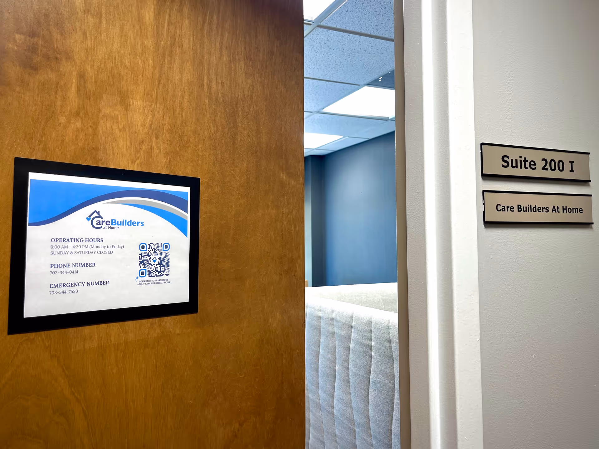 Framed Care Builders At Home sign on a wooden wall beside a doorway.