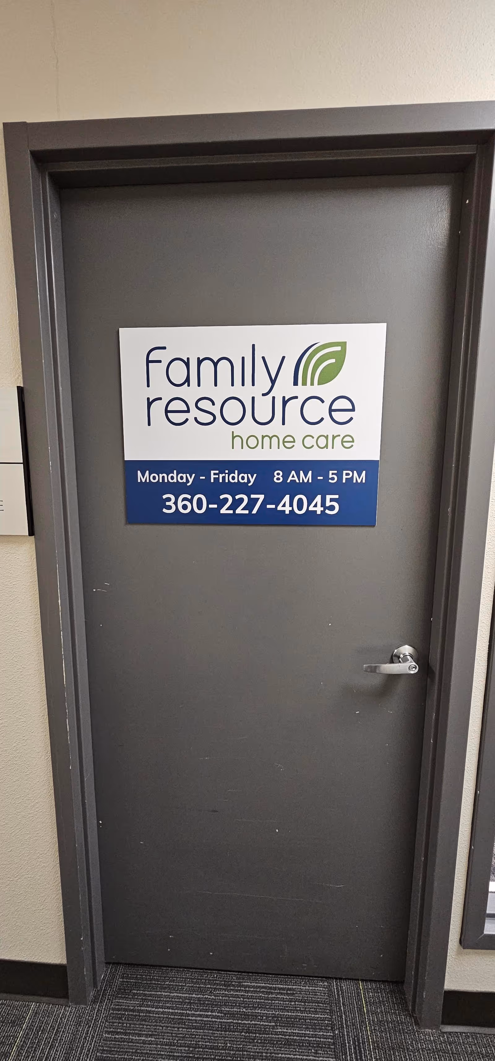 Interior gray door with Family Resource Home Care sign and phone number.
