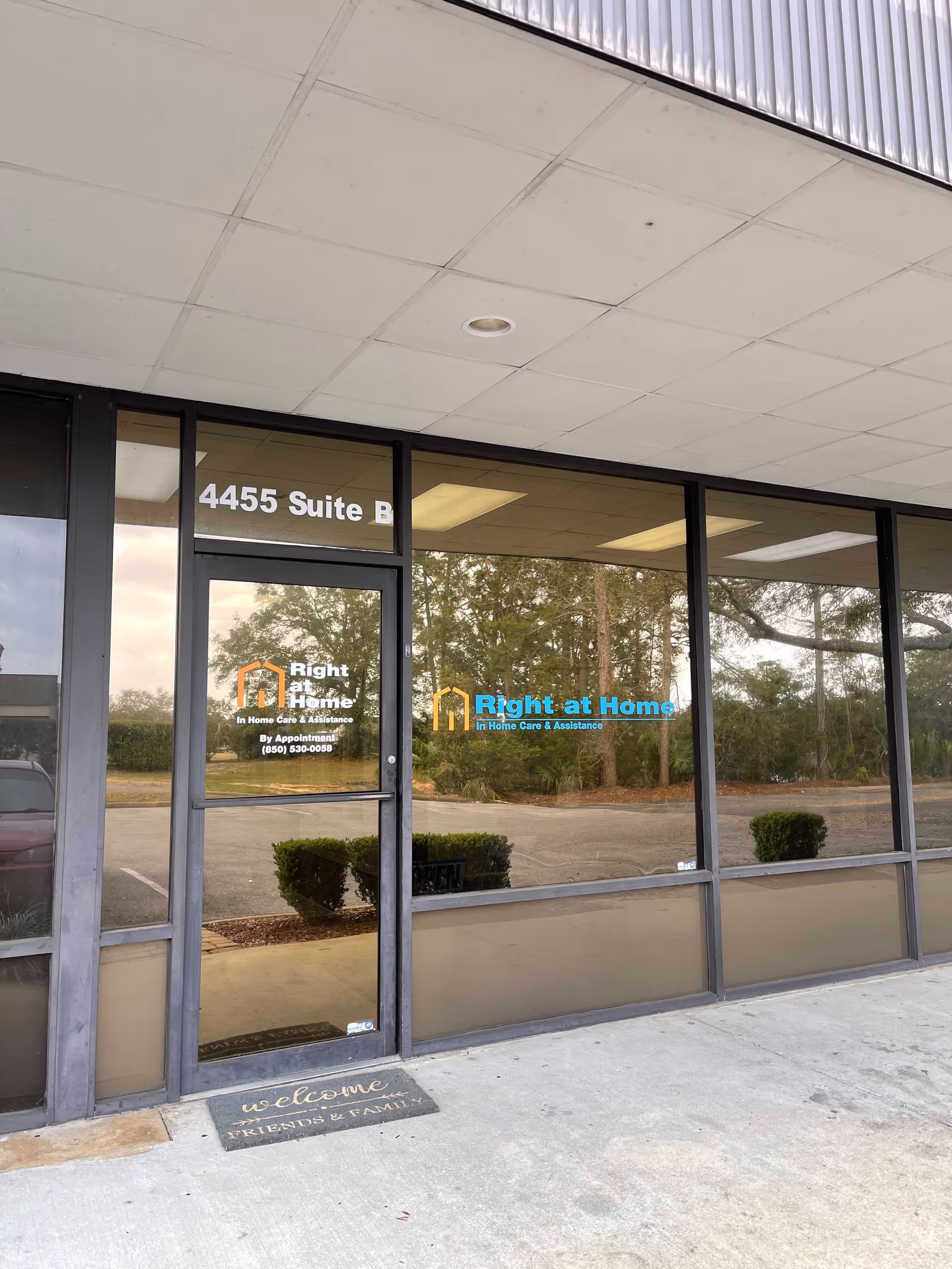 Glass storefront entrance for Right at Home senior care, with logo and plants outside.