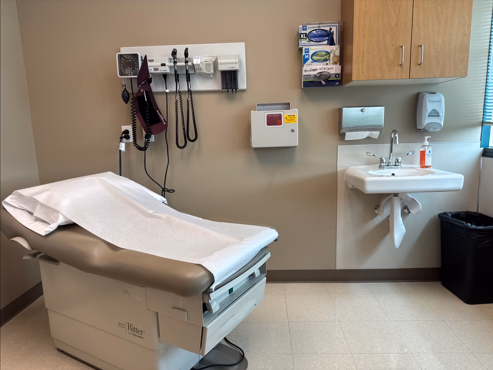 Examination room in a senior living facility with a medical chair and sink.