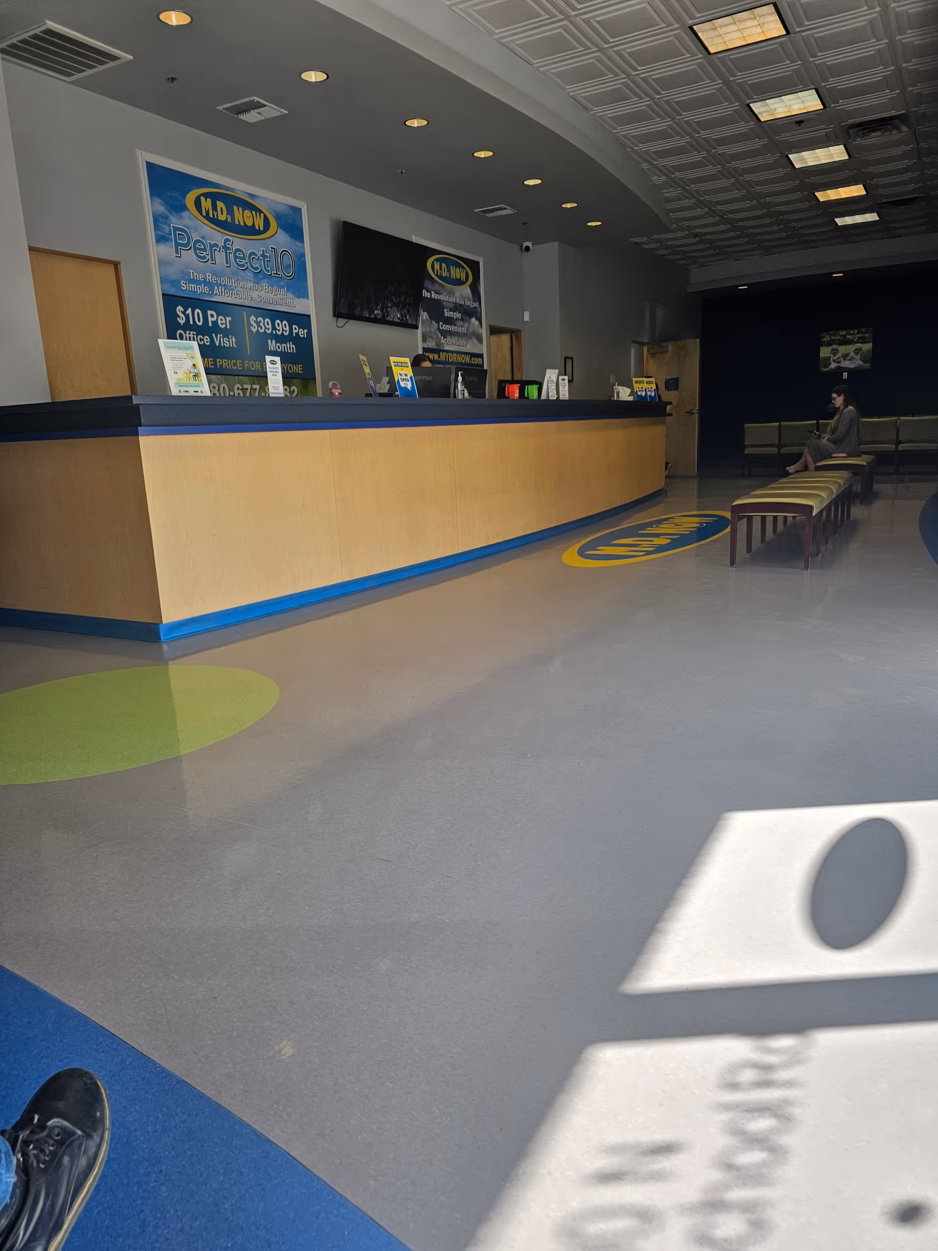 Lobby reception area with a long wooden counter and waiting benches.