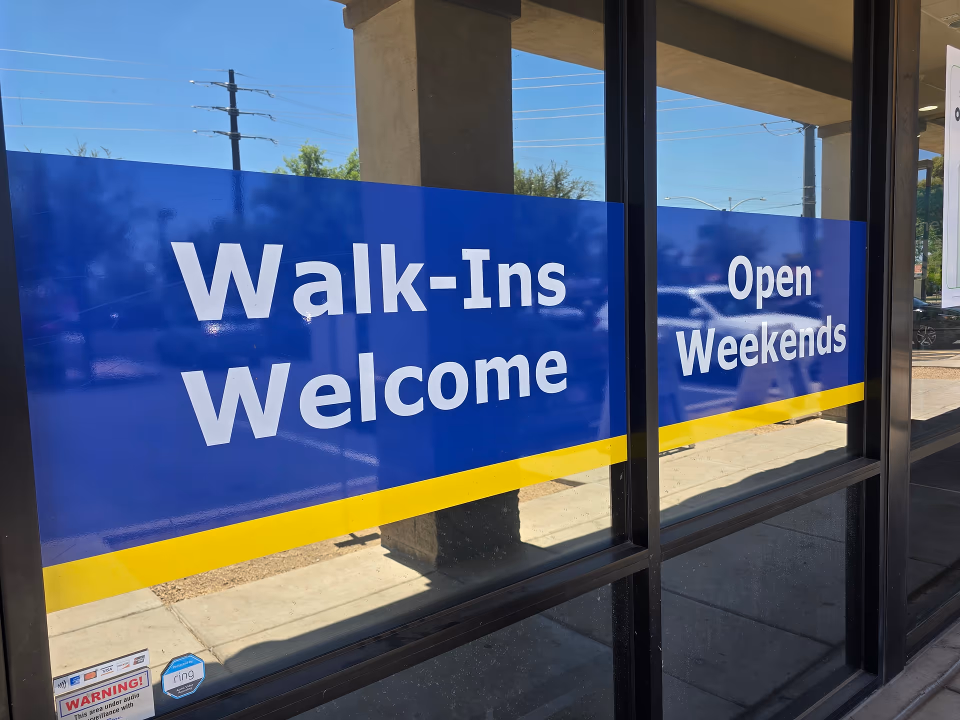 Blue signage on glass doors reads Walk-Ins Welcome and Open Weekends.