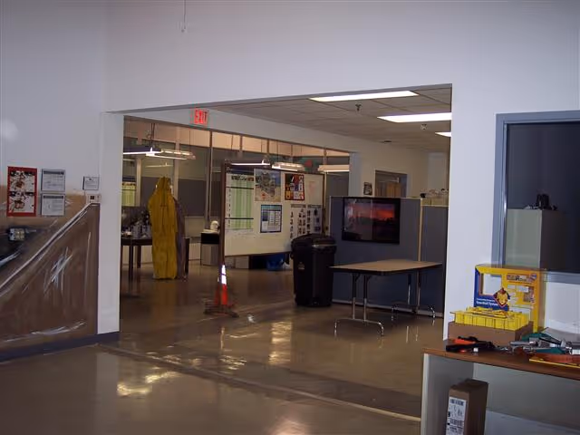 Open interior lobby with bulletin boards, doorway to back rooms, and a yellow gown.