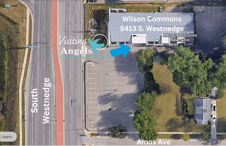 Aerial view of Visiting Angels exterior with parking lot and surrounding trees