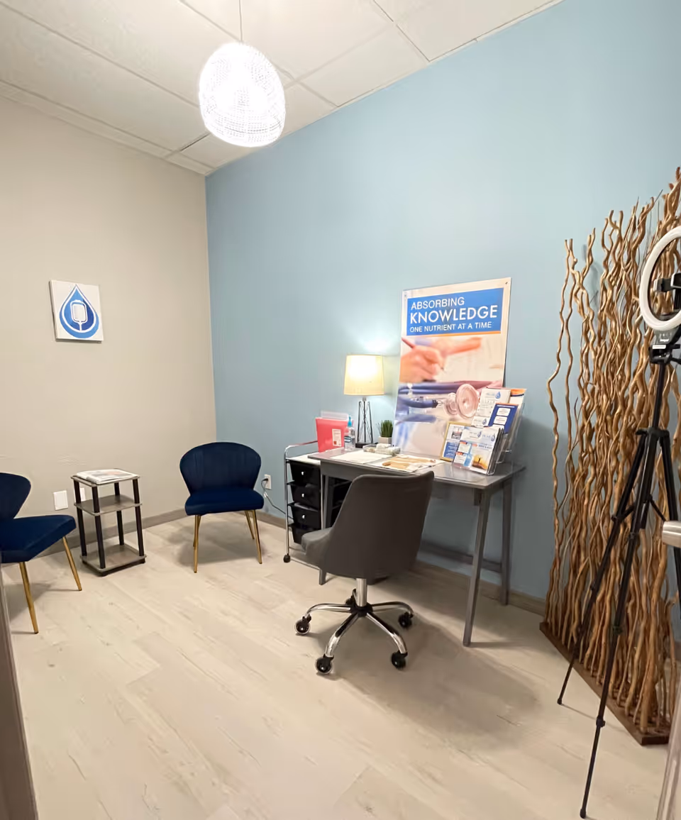 Office-style consultation area with desk, chairs, brochures, and blue wall.