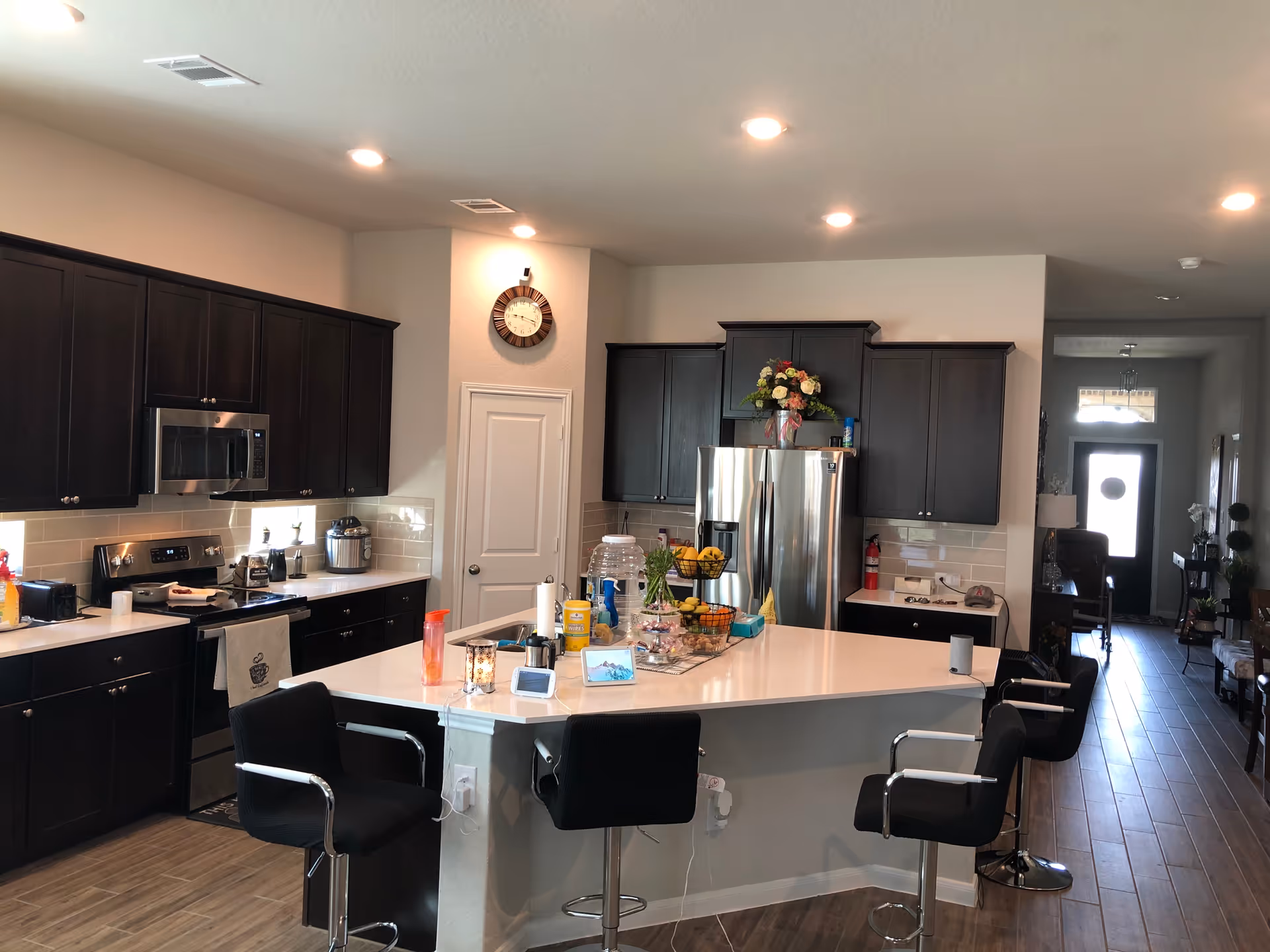 Modern kitchen with dark cabinets, stainless steel appliances, and a central island.