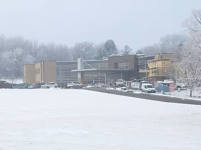 Snow-covered exterior of Shenandoah Medical Center with a line of parked cars.