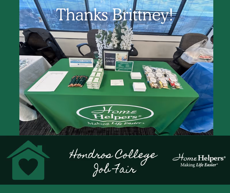 Promotional table with Home Helpers materials at a job fair event.