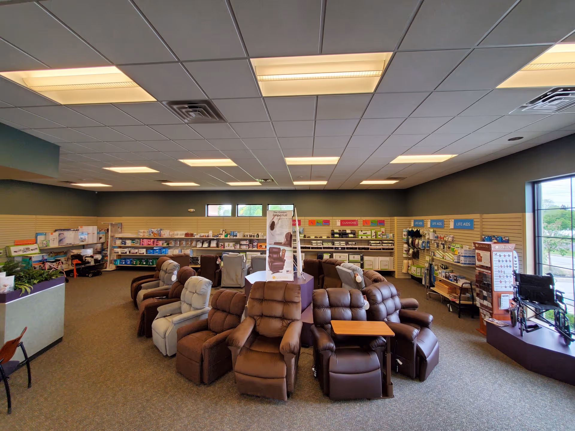 Spacious lounge with brown recliners and shelves lining the back wall.
