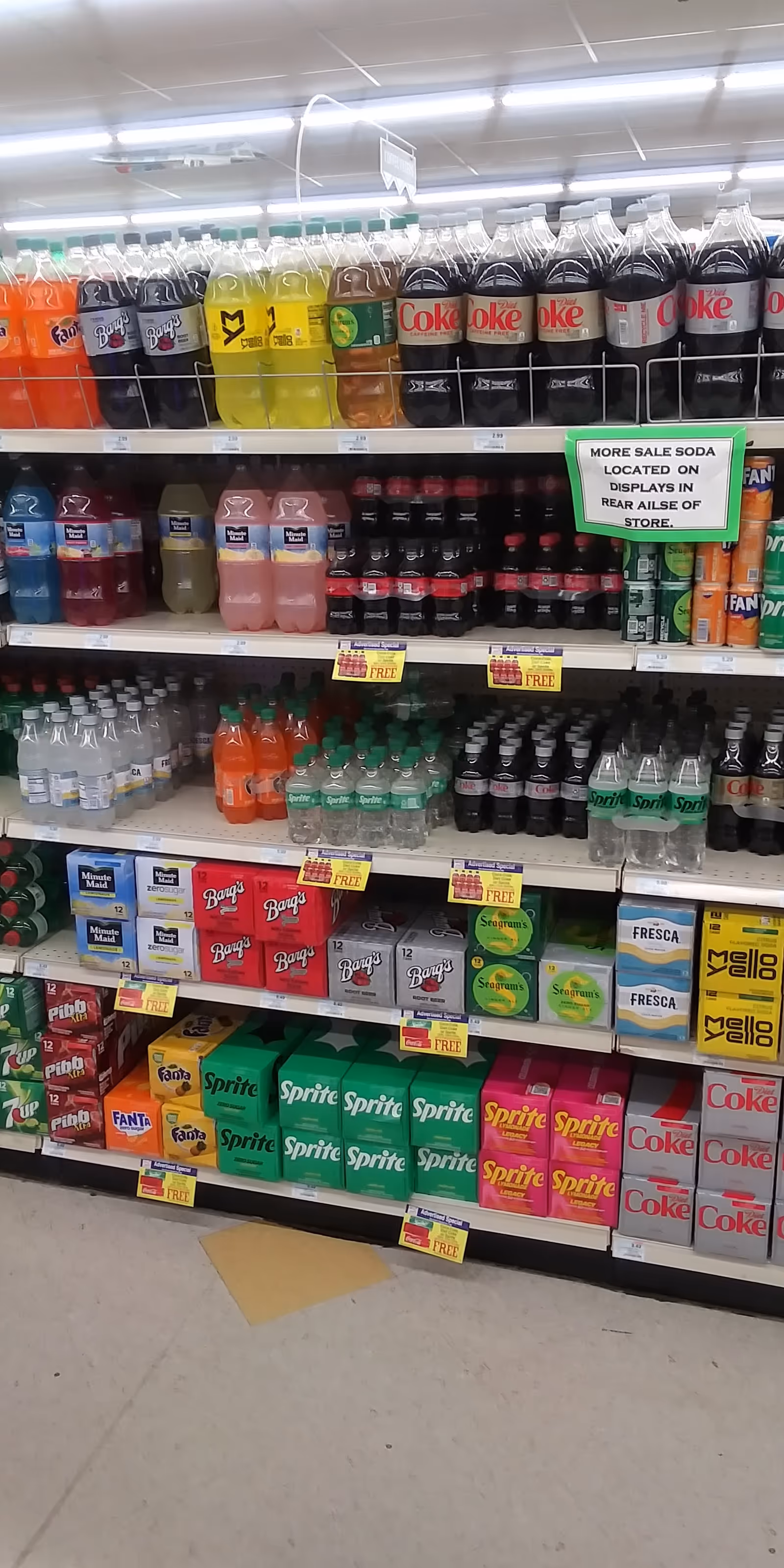 Indoor Discount Drug Mart store aisle filled with soda bottles and assorted beverages on shelves.