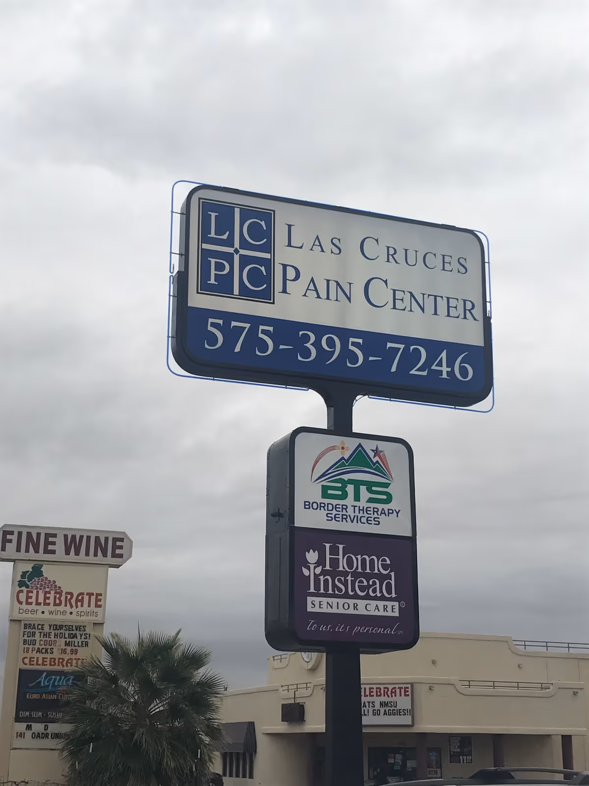 Tall outdoor signpost displaying Home Instead Senior Care and other businesses.
