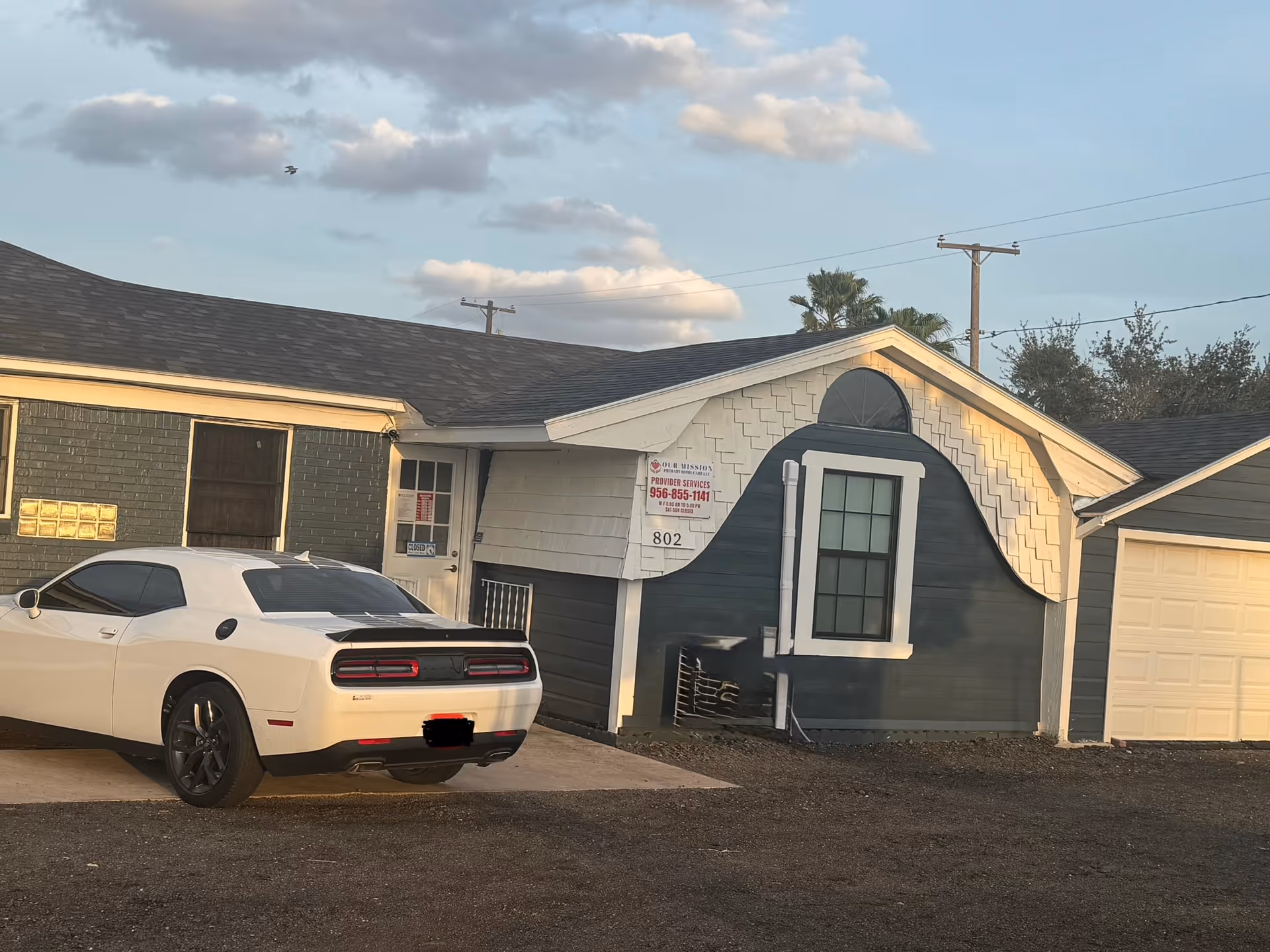 Exterior view of small Our Mission Primary Home Care building with a white car in parking.