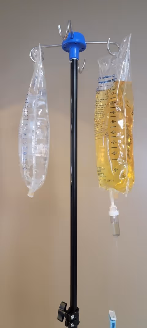 IV drip stand with two bags in a senior living facility room