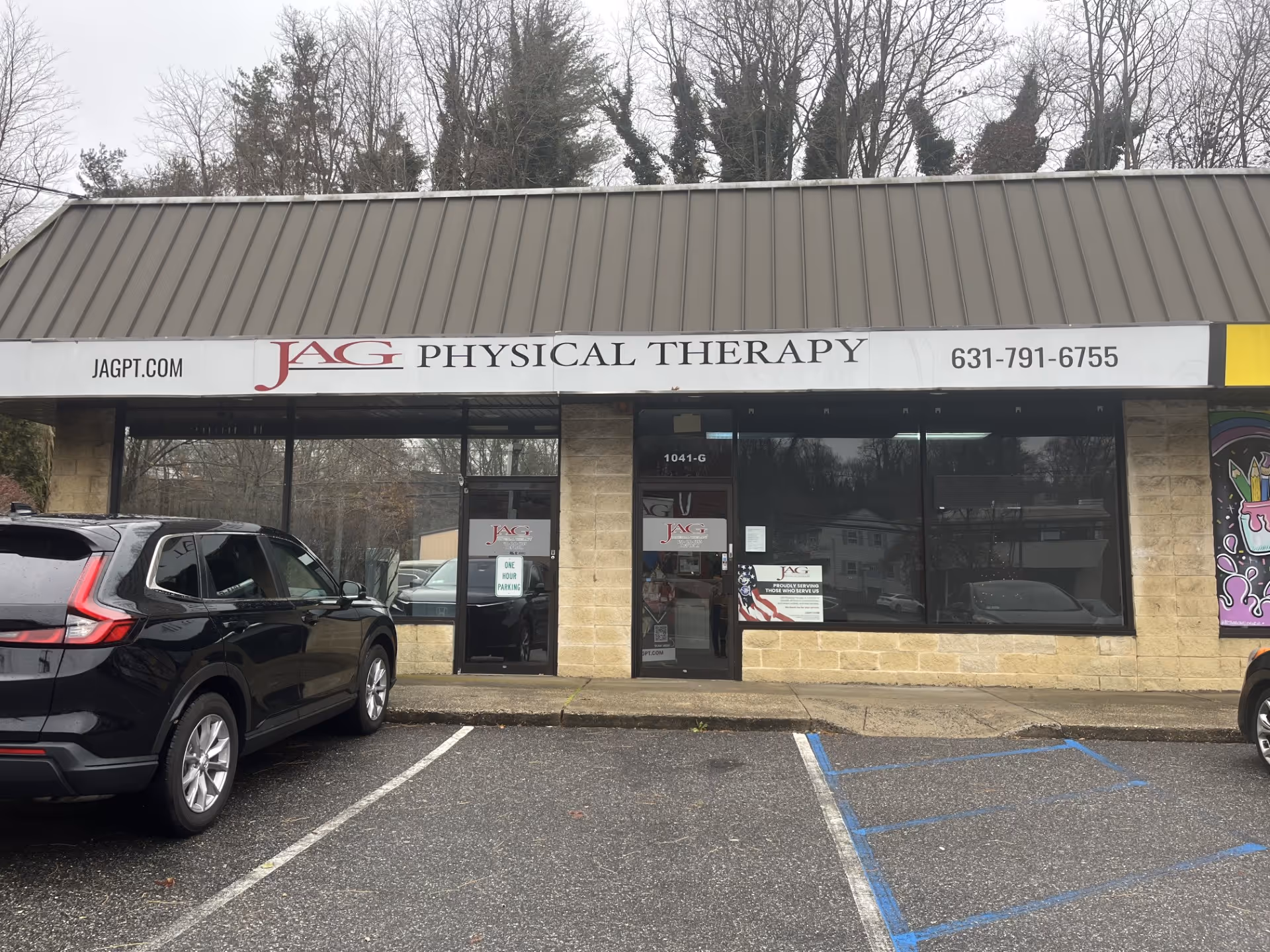 Front exterior of JAG Physical Therapy storefront with sign and parked cars.