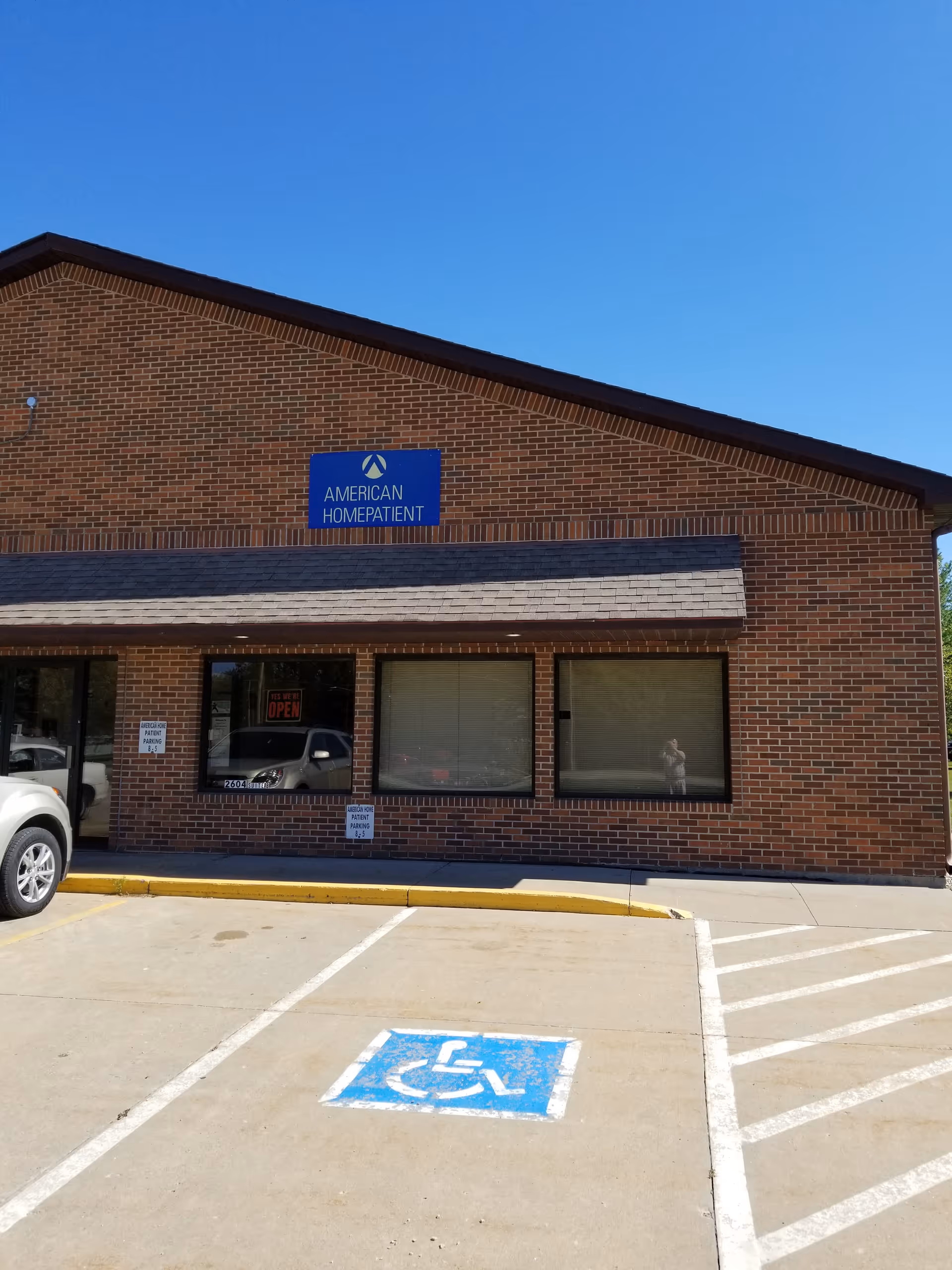 Brick facility exterior with American HomePatient sign and wheelchair accessible parking.
