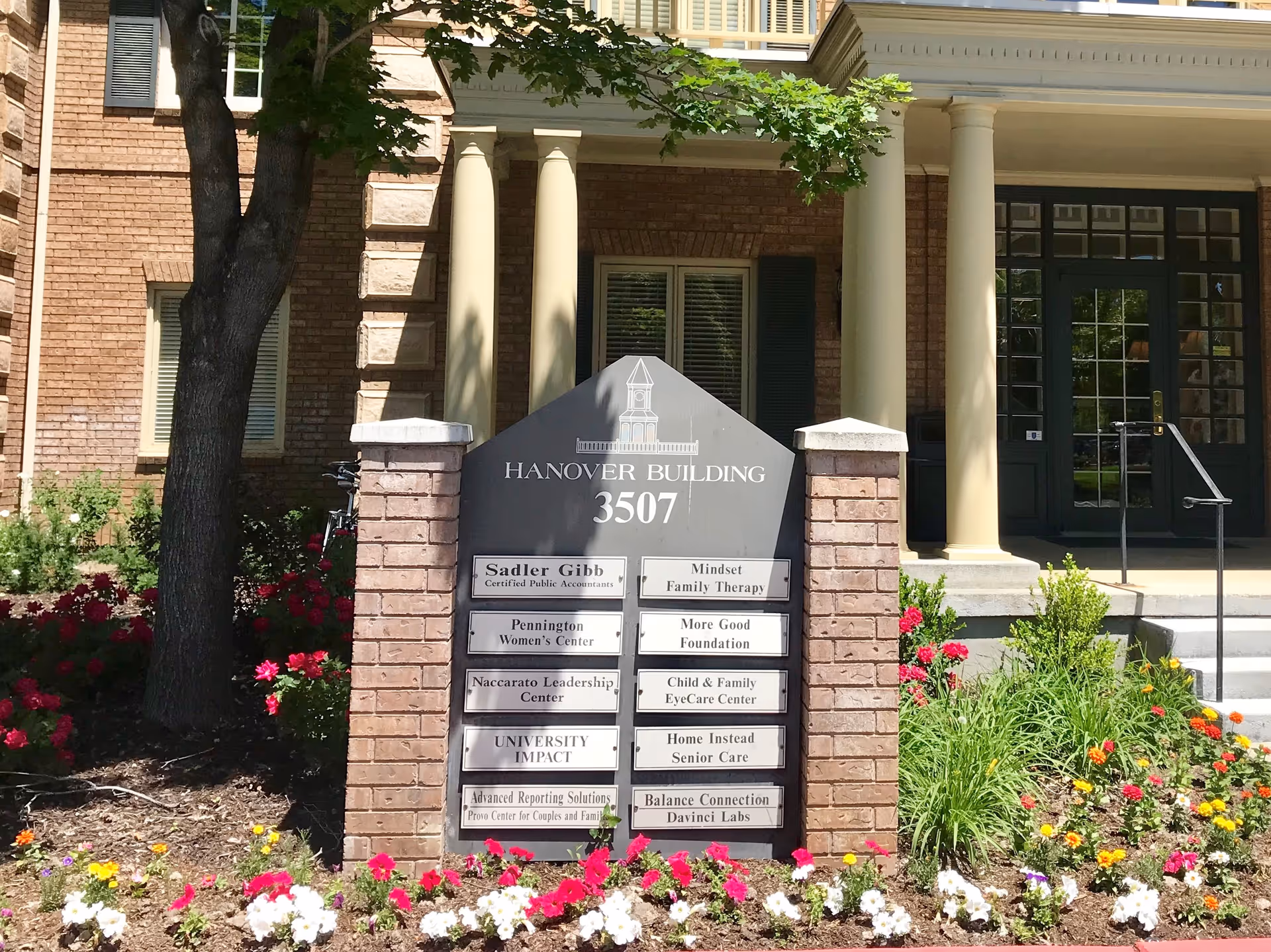Exterior view of Hanover Building entrance with brick pillars and flowers