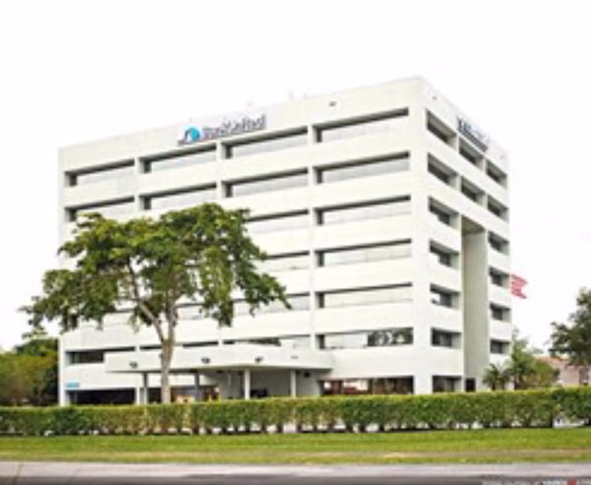 White multi-story BrightStar Care building with trees and manicured lawn.