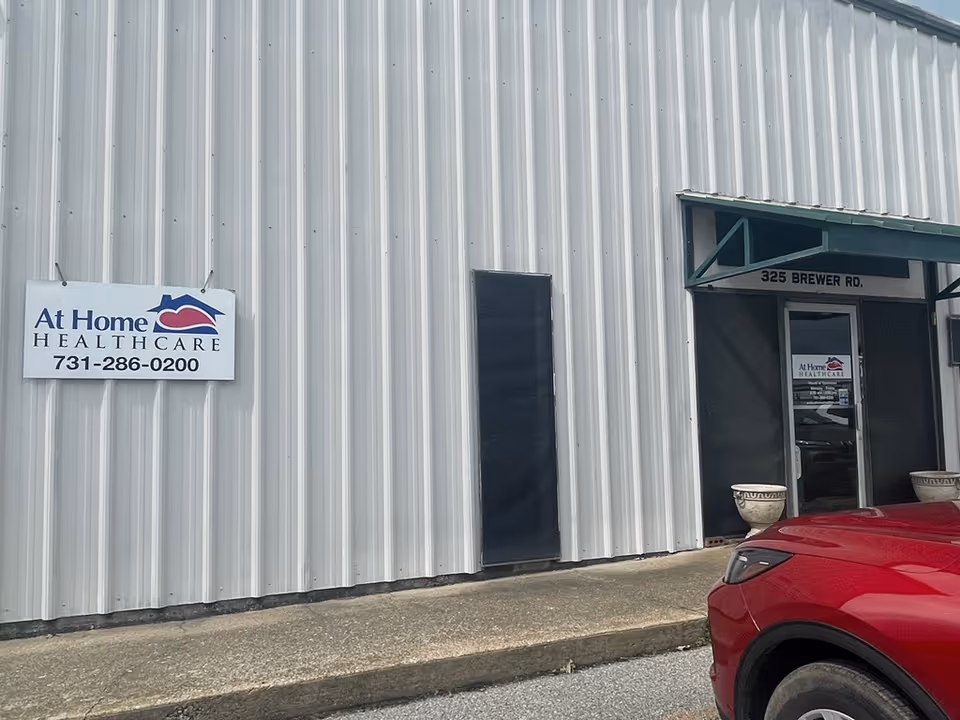 Exterior view of a metal-clad building with At Home Healthcare sign and entrance.