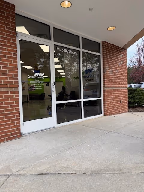 Brick storefront with glass doors labeled MobilityWorks, with interior activity visible through windows.