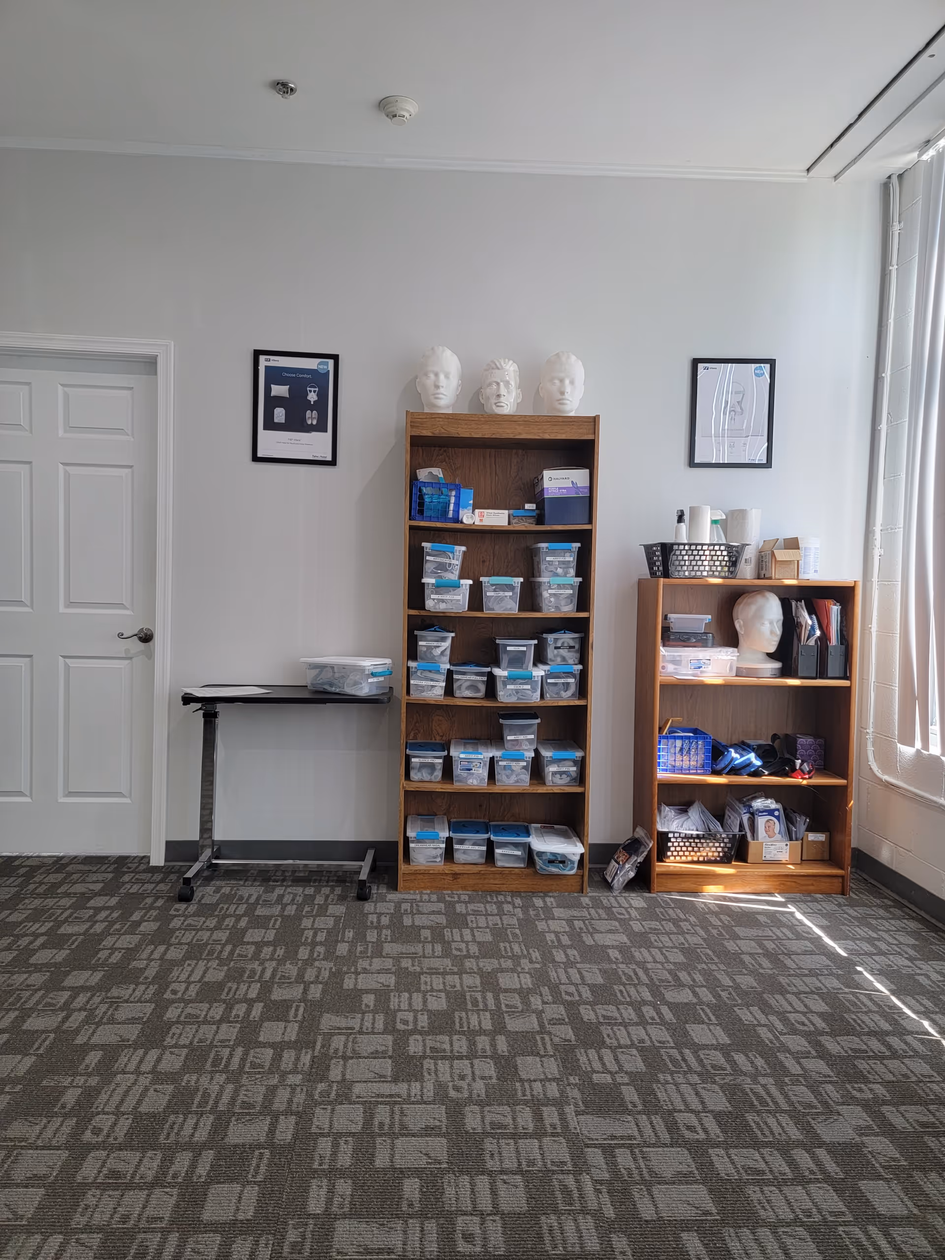 Interior room with shelves, bins of supplies, and mannequin heads.