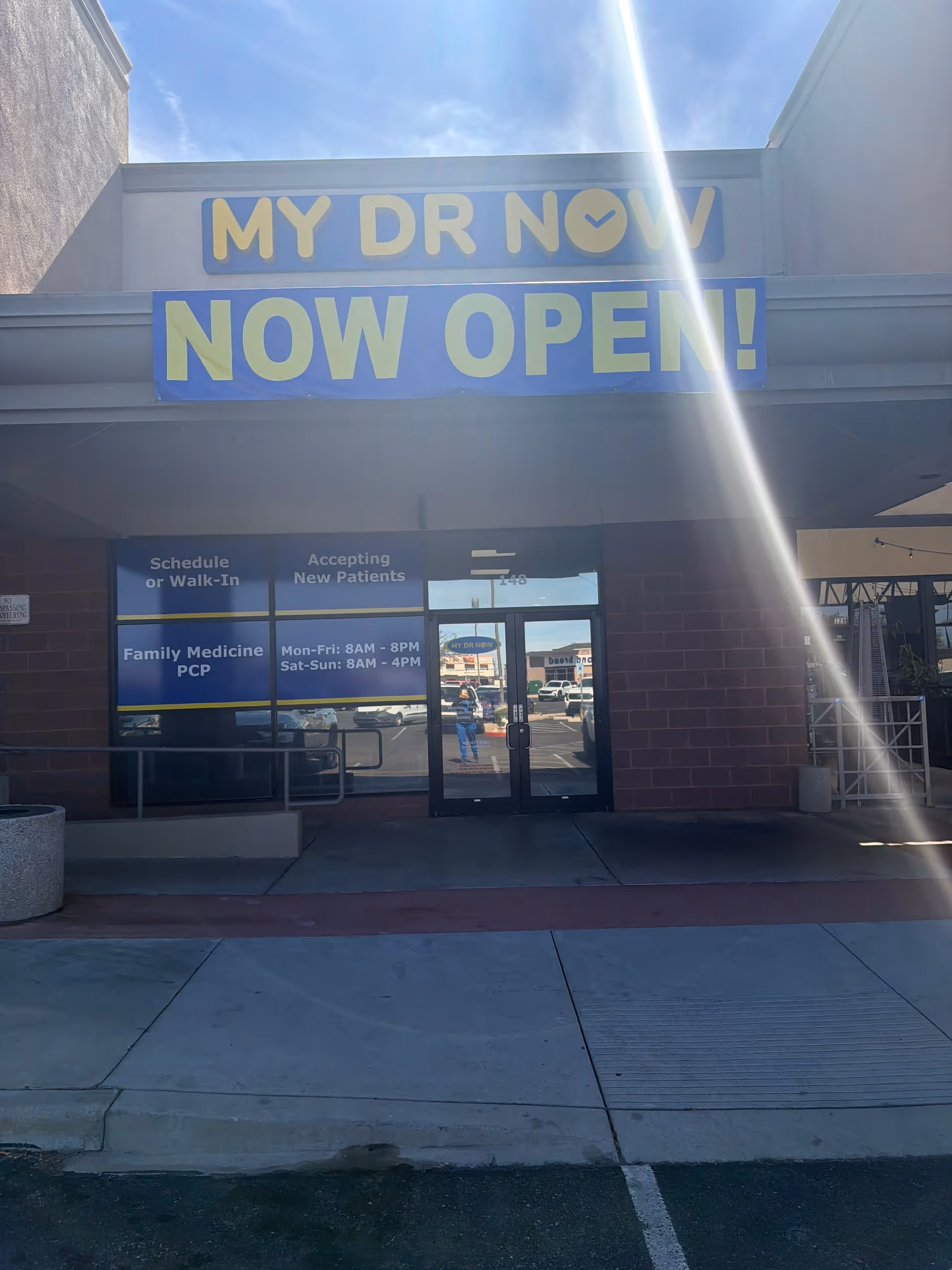Front of a building with a large MY DR NOW NOW OPEN banner above the entrance