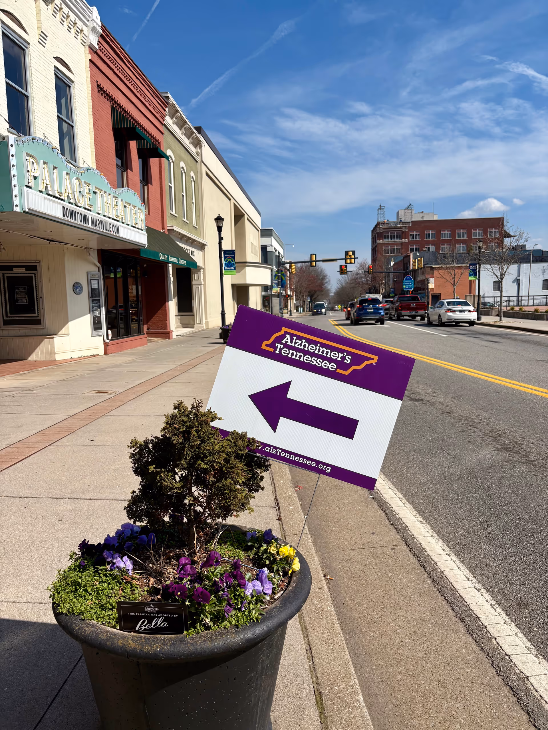 Street view with planter and a purple Alzheimer's sign on the sidewalk