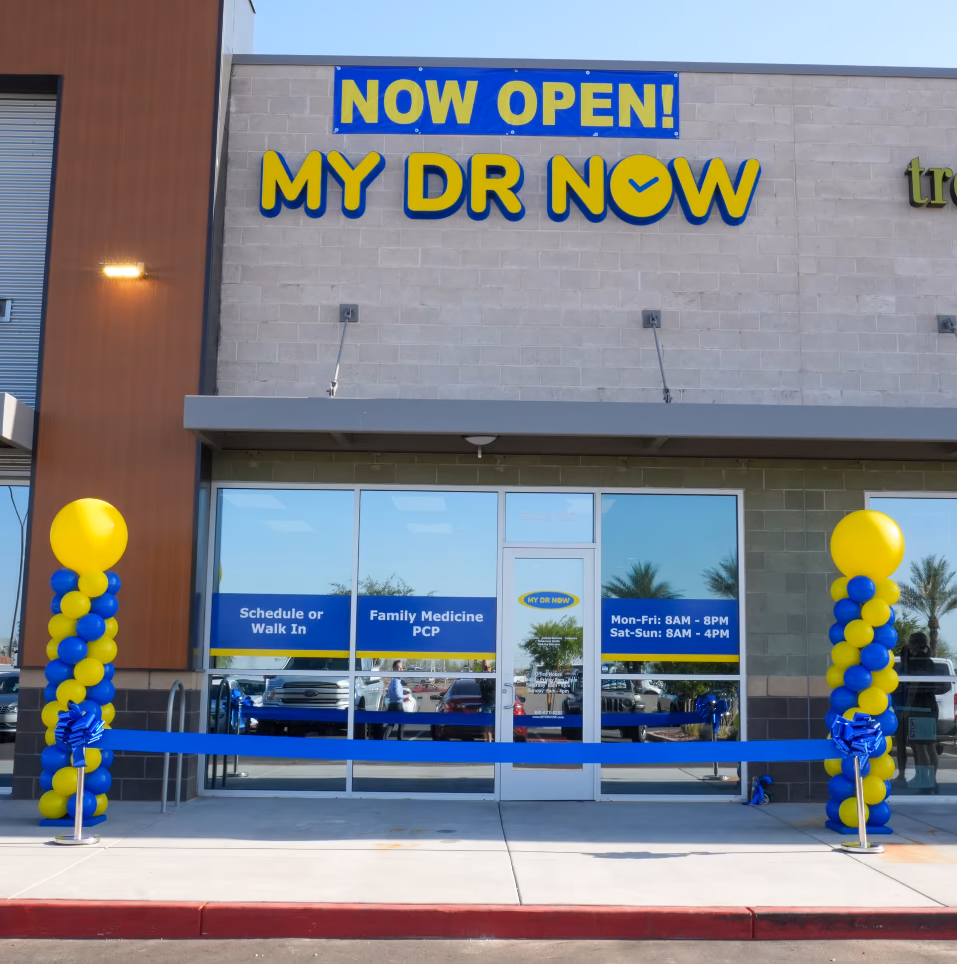 Exterior storefront of MY DR NOW clinic with balloons and a ceremonial ribbon.