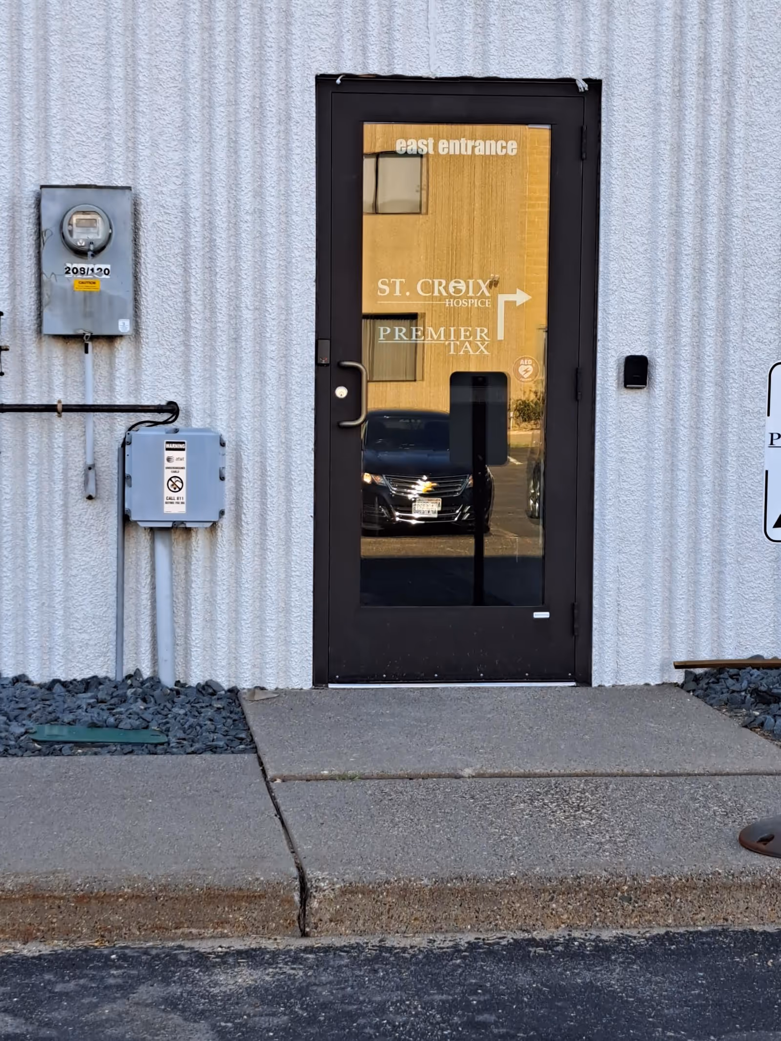 Exterior view of the east entrance with a glass door at St. Croix Hospice.
