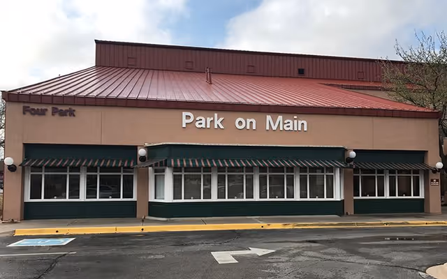 Exterior view of a building front labeled Park on Main with green awnings.