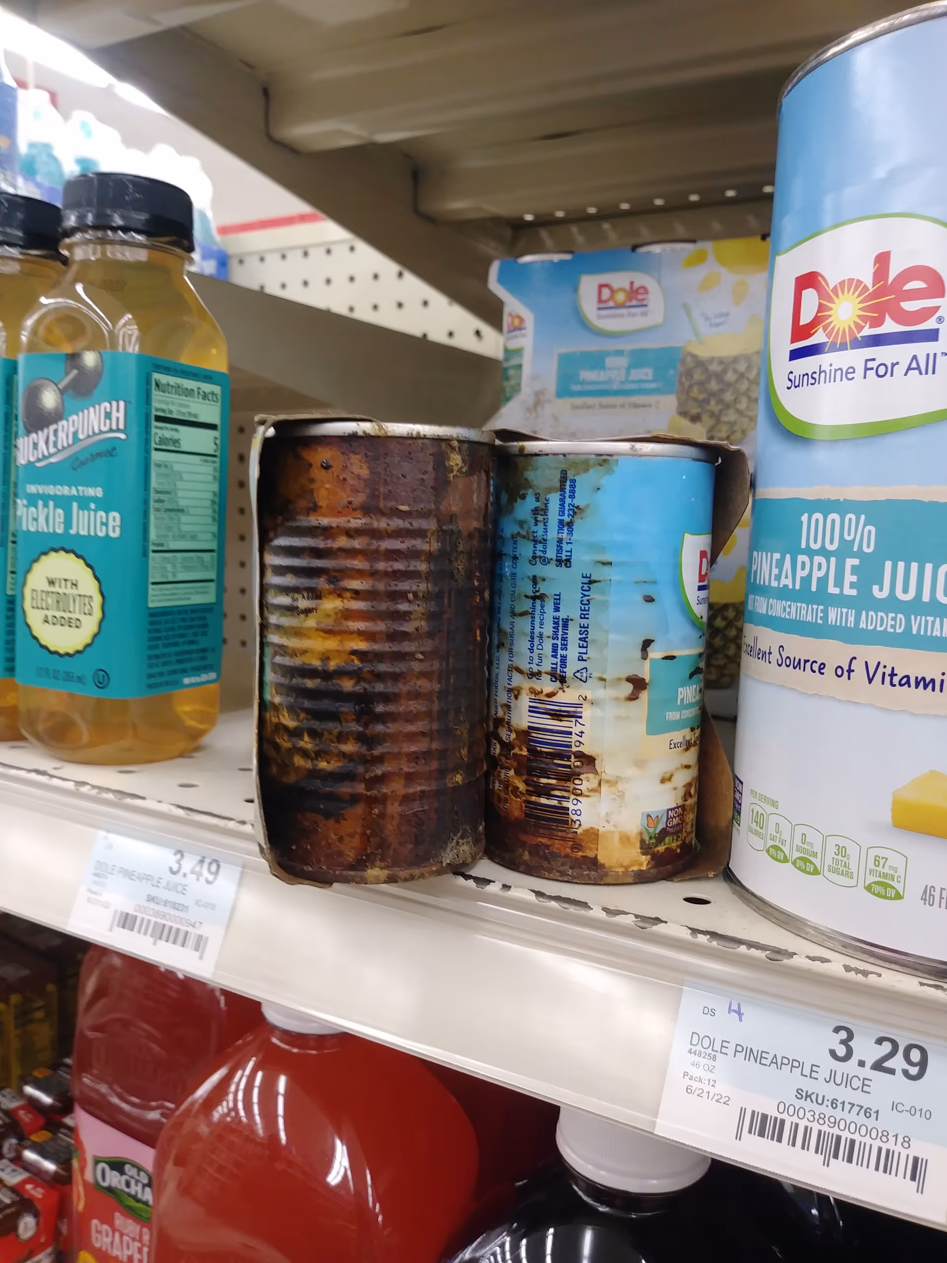 Shelf of juice bottles and cans on a Discount Drug Mart store aisle