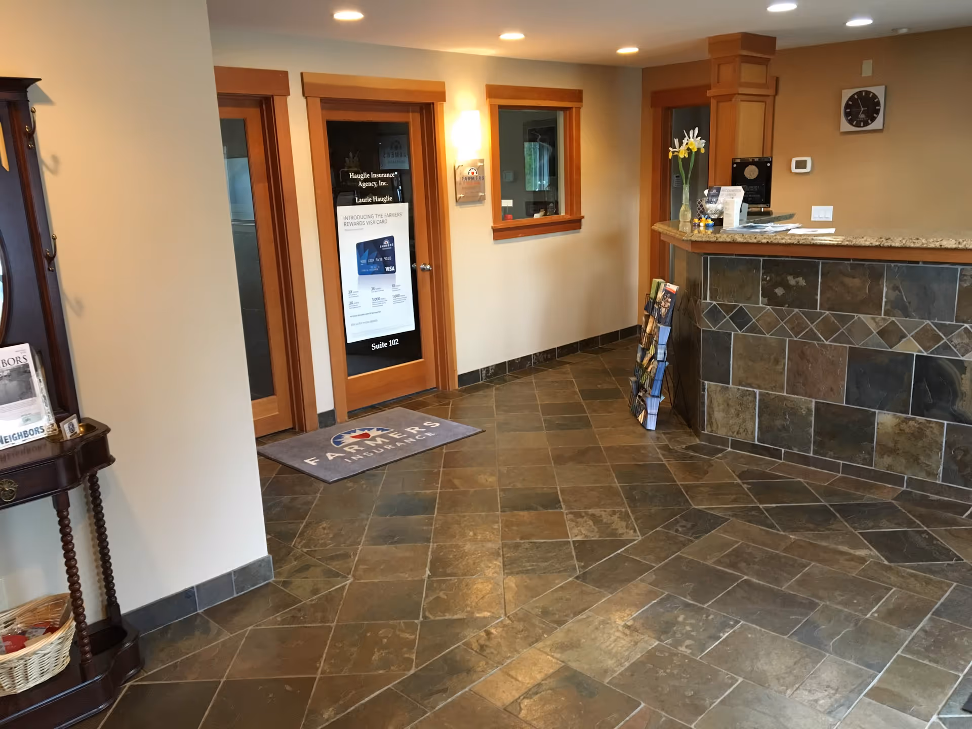 Lobby area with a reception desk, tiled floor, and brochure stand.