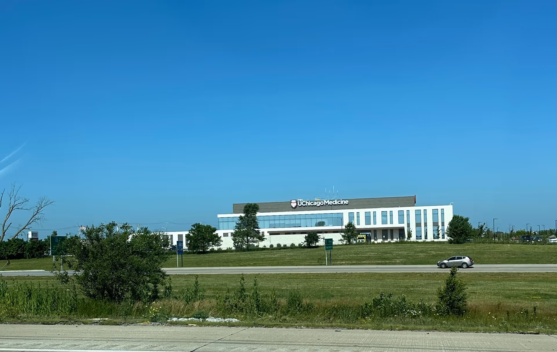 Exterior view of a modern hospital building with UChicago Medicine sign and green lawn