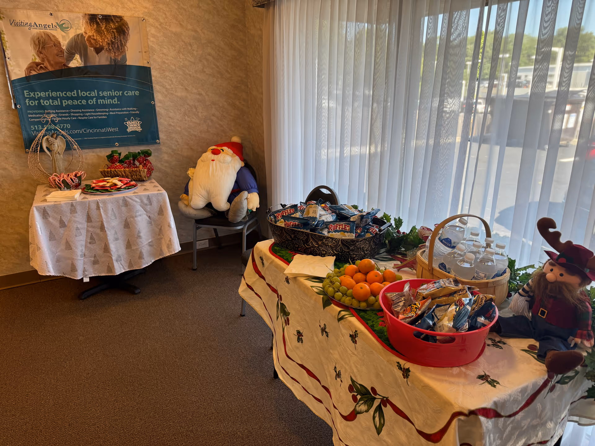Indoor senior home care room with holiday tables, snacks, drinks, and festive decorations.