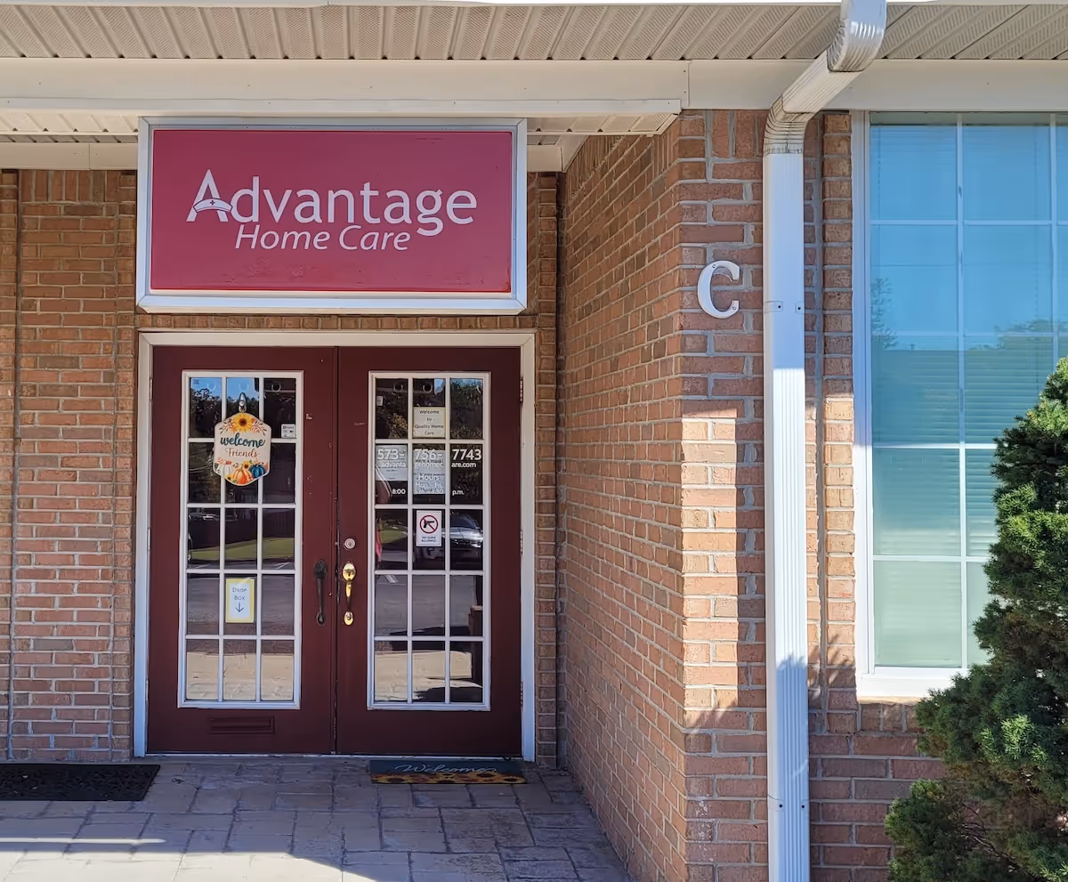 Advantage Home Care building entrance with maroon double doors and brick exterior.