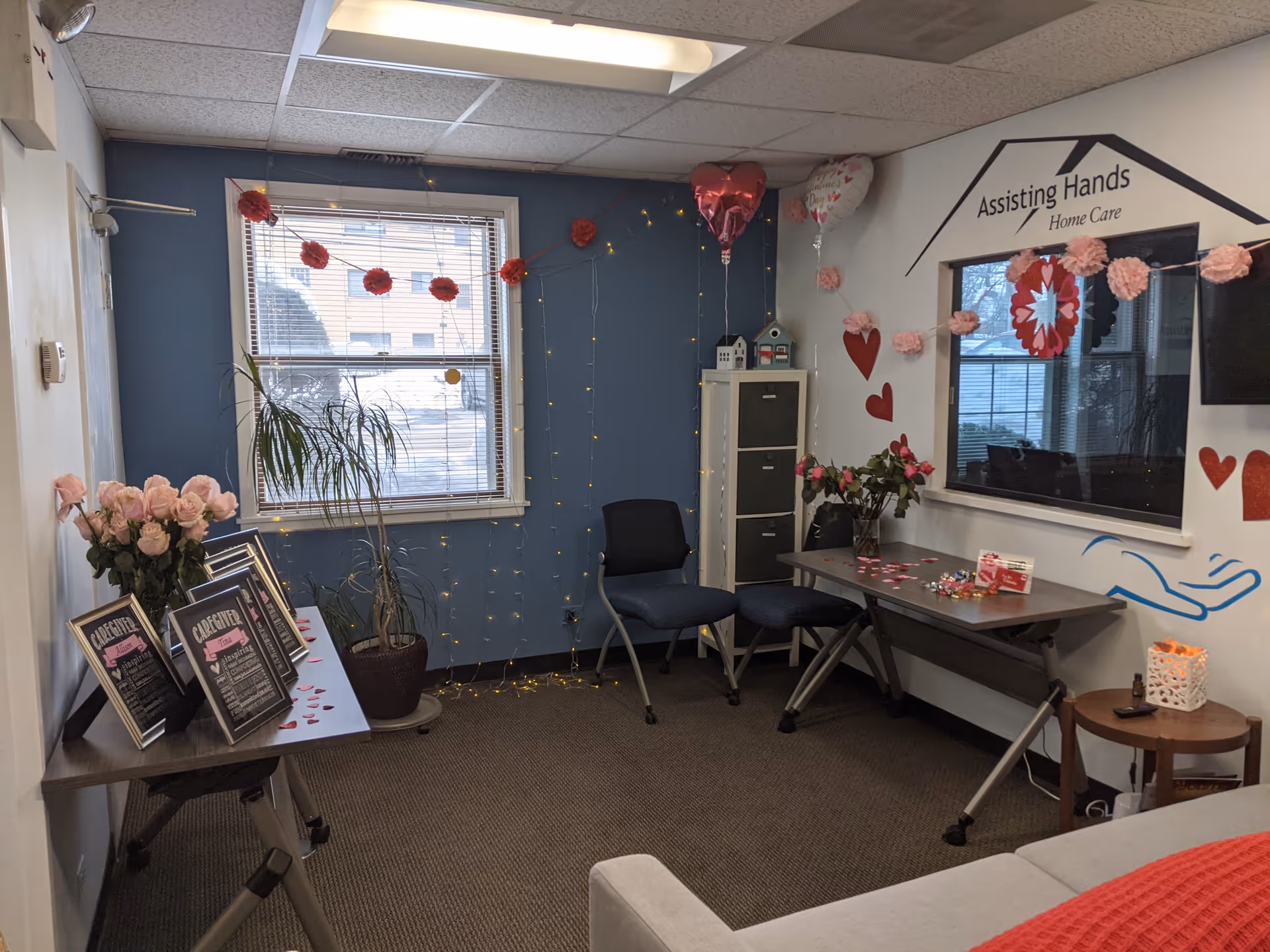 Reception area inside Assisting Hands Home Care with valentines decor and seating.